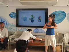 Facilitadora del curso Dirección Consciente explicando el módulo Cabeza, Corazón, Manos ante un grupo de tripulantes